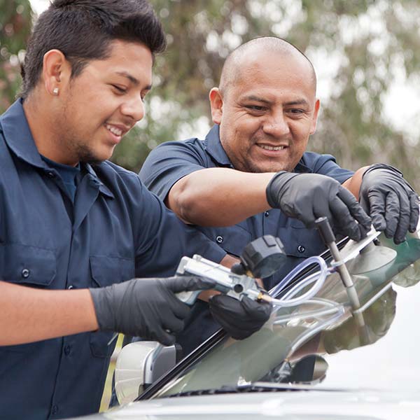 2 men doing auto glass repair work